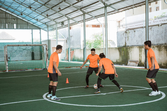 futsal player tries to prevent another player from passing