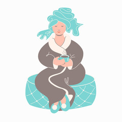Woman in bathrobe with cup of tea