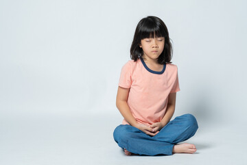 Asian girl meditating on white background, lovely kid