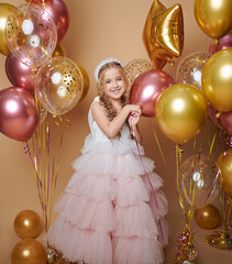 Cute girl on a pink background with balloons