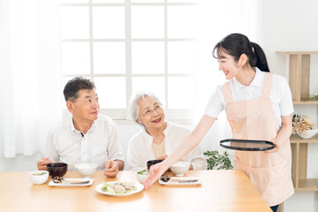 高齢者の食事を運ぶ女性（栄養士・配膳）
