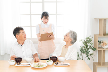 高齢者の食事をチェックする女性（栄養士）
