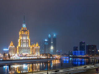Obraz premium Illuminated high-rise stalinist building near river at winter night in Moscow, Russia. Historic name is Hotel Ukraine.