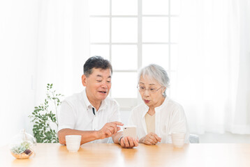 Obraz na płótnie Canvas スマホを使う高齢者夫婦（笑顔） 
