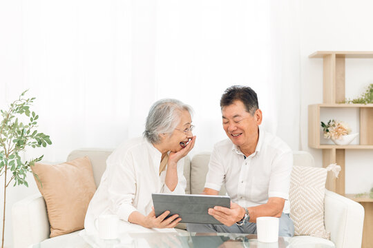 タブレットPCを見る高齢者夫婦（笑顔）
