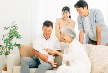 Fototapeta premium 赤ちゃんを抱いた老夫婦と若い夫婦（里帰り） 