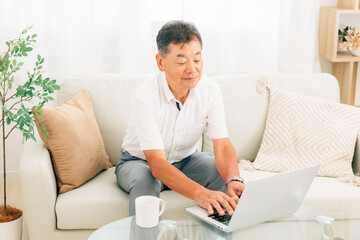 Fototapeta premium パソコンを使う高齢者男性（笑顔） 