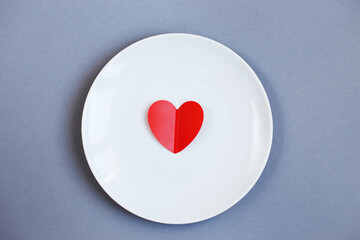 Red Heart on a white plate on grey background