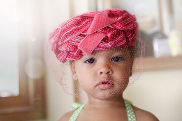 Young girl wearing a hat with a net at a wedding tea party - Powered by Adobe
