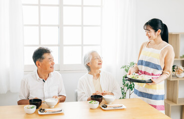老夫婦に食事を運ぶ女性（家事代行・家政婦・ホームヘルパー）