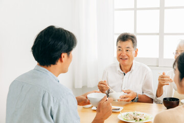 楽しい食事をする老夫婦と若い夫婦（笑顔）
