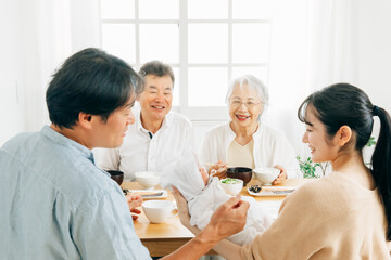 里帰り出産・食事をする老夫婦と若い夫婦
