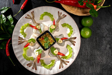 Raw Shrimp in fish sauce and many herbs. A delicious recipe from Asia and spices ingredients for cooking on dark black wooden table background, Thai food, Asian foods, Thailand restaurant menu