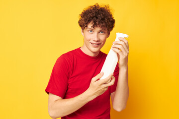 Young curly-haired man detergents home care posing isolated background unaltered