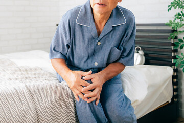 寝室で体調を崩す高齢者男性（膝痛）
