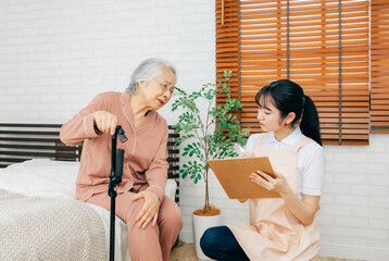 笑顔の高齢者女性と介護士の女性（訪問介護・在宅介護）（膝）