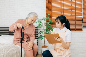 笑顔の高齢者女性と介護士の女性（訪問介護・在宅介護）（膝）