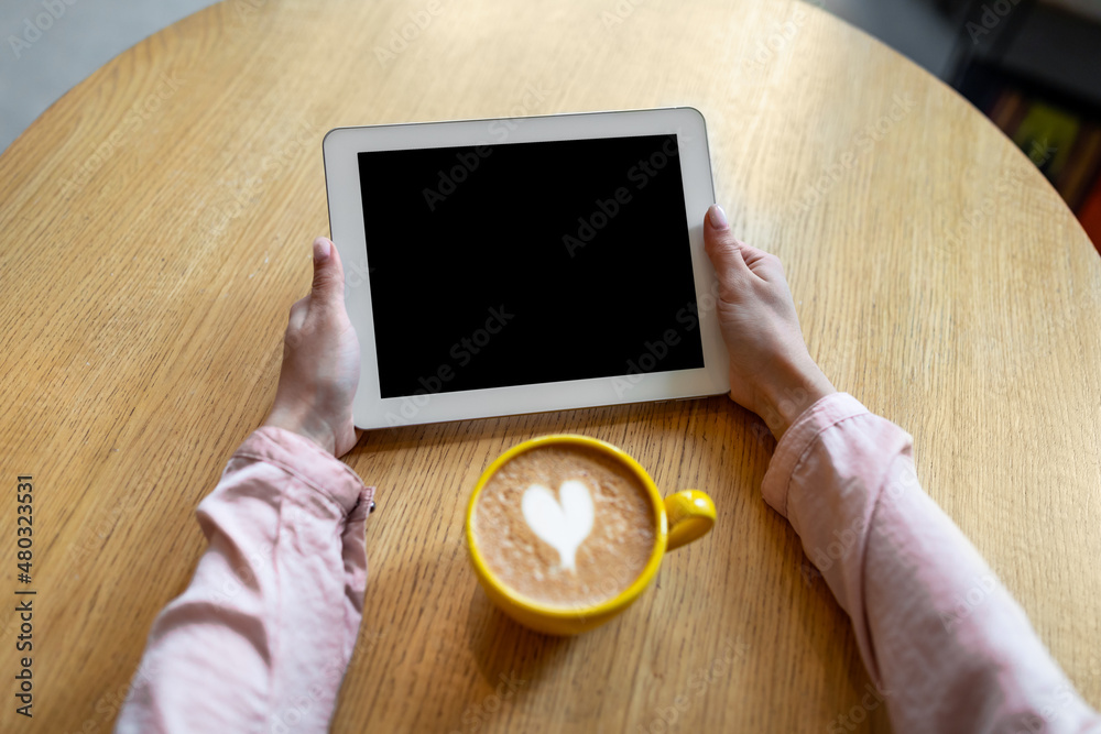Poster breakfast at cafe. unrecognizable lady holding tablet with empty blank screen at coffee break, mocku