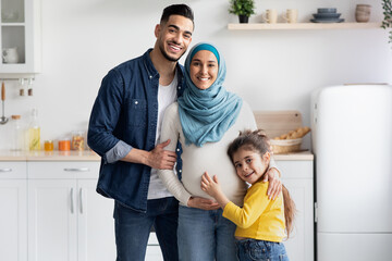 Islamic Expecting Family. Happy Pregant Muslim Woman Posing With Husband And Daughter