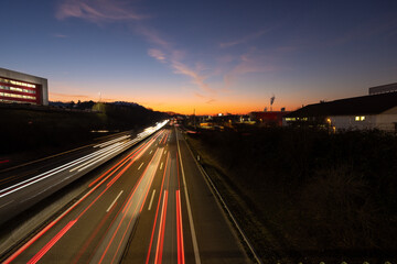 Autobahn mit Verkehr bei Nacht in der Dämmerung mit Lichterstreifen