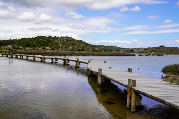 Fototapeta na wymiar Bridge Over River Against Sky wooden pontoon on Peyriac-de-Mer in france