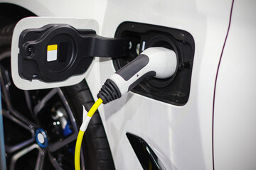 Electric car plug in with ev charger cable station in concept of future clean energy for environment