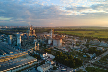 Obraz premium Aerial view of cement factory with high concrete plant structure and tower crane at industrial production area. Manufacture and global industry concept