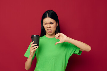 woman in a green t-shirt black glass with a drink displeasure