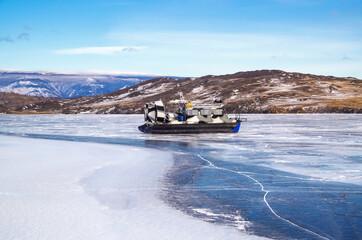 Hovercraft on Lake Baikal. Airboat, winter transport extreme. Hovercraft sliding fast on the surface of the transparent frozen Lake Baikal.