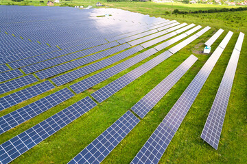 Aerial view of solar power plant on green field. Electric panels for producing clean ecologic energy.