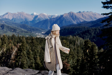 Fototapeta na wymiar tourist in autumn clothes stands on a rock landscape blue sky landscape