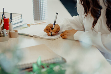 Woman writing in notebook on desk