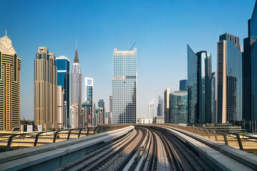 Fototapeta na wymiar Dubai city center, with skyscrapers and train metro, United Arab Emirates. Financial center with skyscrapers and subway rails.