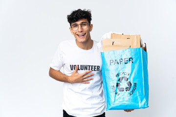 Young man holding a recycling bag full of paper smiling a lot