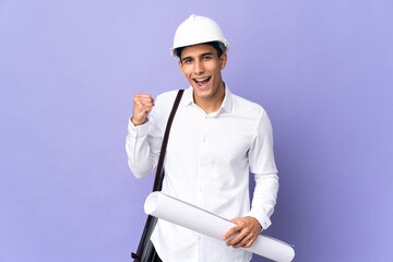 Young architect man isolated on background celebrating a victory in winner position