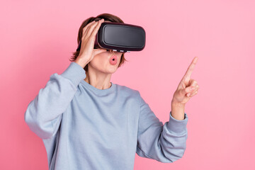 Portrait of attractive trendy amazed girl wearing digital helmet touching copy space isolated over...