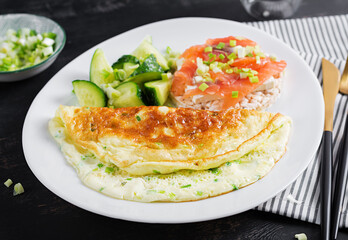 Breakfast. Omelette with green onions and sandwich with salmon on white plate.  Frittata - italian omelet.
