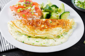 Breakfast. Omelette with green onions and sandwich with salmon on white plate.  Frittata - italian omelet.