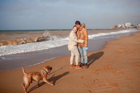 Happy Couple, Overweight Woman And Man Walking In The Beach With Dog