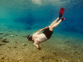 man in diving mask snorkeling in sea water