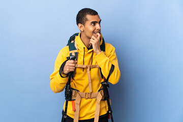 African American man with backpack and trekking poles over isolated background nervous and scared