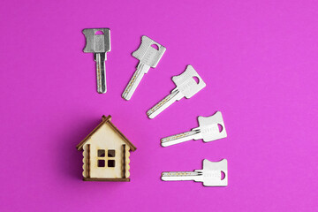 House keys and miniature house model on a colorful bright background. Top view. Home buying concept. Fashionable colorful photo. Trendy flat lay concept.