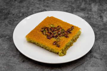 Pistachio kadayif dessert on dark background. Traditional Turkish cuisine flavor. close up