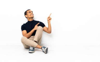 African American man sitting on the floor pointing with the index finger a great idea