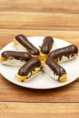 Chocolate eclair cake on wooden background. Traditional french dessert. Pastry products. close up