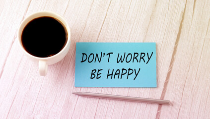 DON'T WORRY BE HAPPY text on the blue sticker with cofee and pen