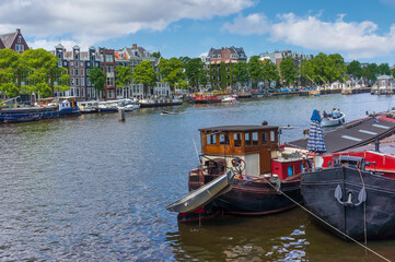 Cityscape, panorama - view of city channel with boats, city of Amsterdam, The Netherlands.