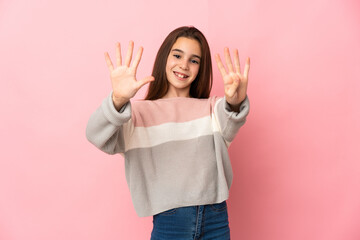 Little girl isolated on pink background counting nine with fingers