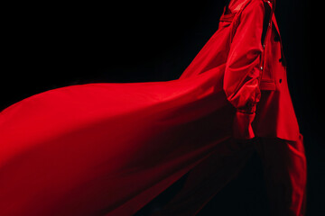 Cropped female figure dressed in a creative long red fancy outfit, costume pants and jacket walking...
