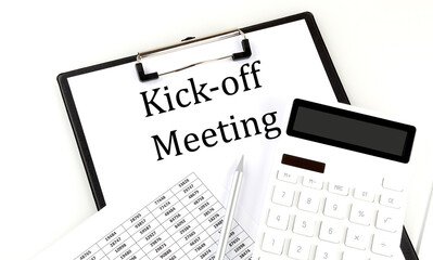 KICK-OFF MEETING text on folder with chart and calculator on white background